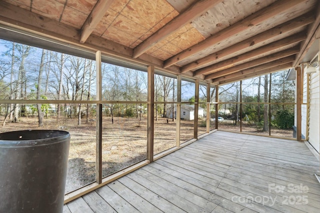 unfurnished sunroom featuring beam ceiling