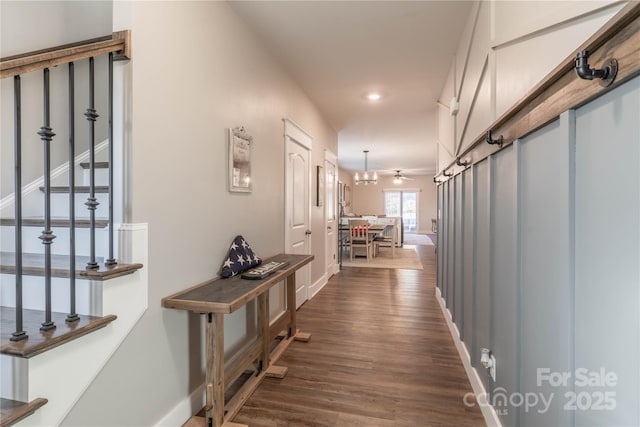 hall featuring a barn door and dark hardwood / wood-style floors