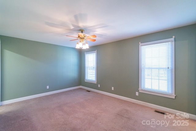 spare room with ceiling fan and light carpet