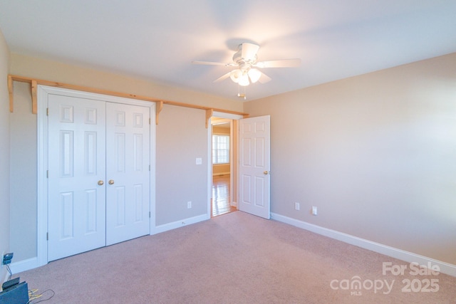 unfurnished bedroom with light carpet, a closet, and ceiling fan