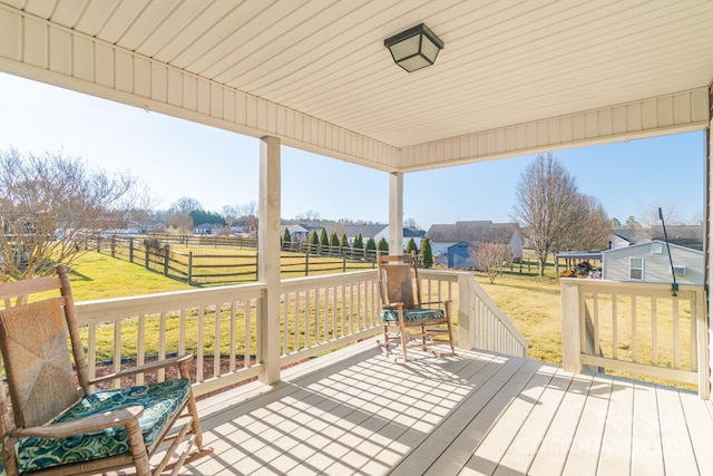 wooden terrace featuring a lawn