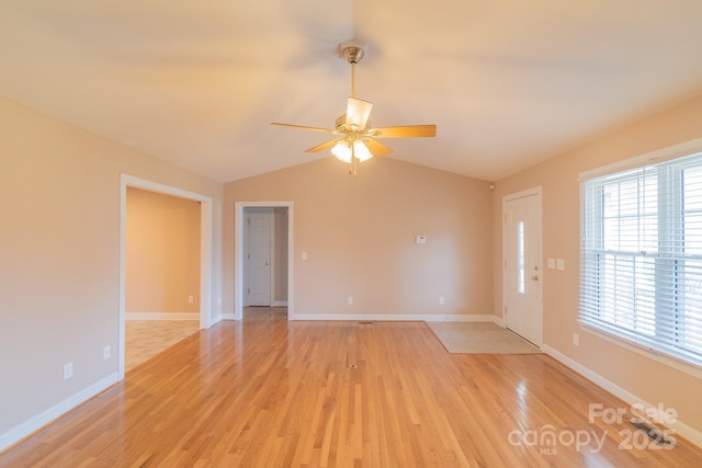 unfurnished room featuring lofted ceiling, a ceiling fan, light wood-style flooring, and baseboards