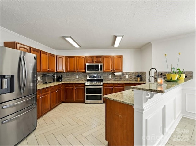 kitchen featuring light parquet floors, backsplash, stainless steel appliances, light stone counters, and kitchen peninsula