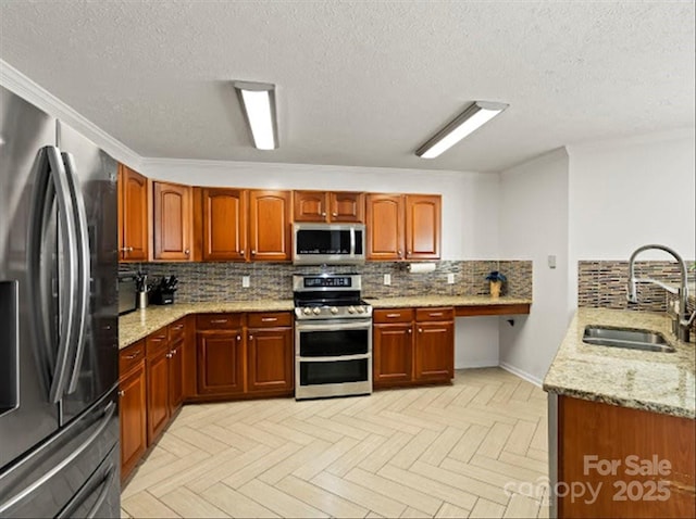 kitchen featuring sink, light stone counters, kitchen peninsula, stainless steel appliances, and light parquet flooring