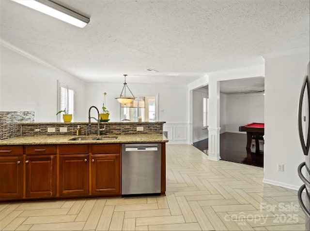 kitchen featuring sink, light stone counters, dishwasher, pendant lighting, and light parquet flooring