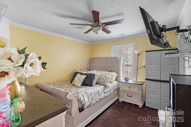 bedroom featuring ceiling fan, ornamental molding, a textured ceiling, and dark colored carpet