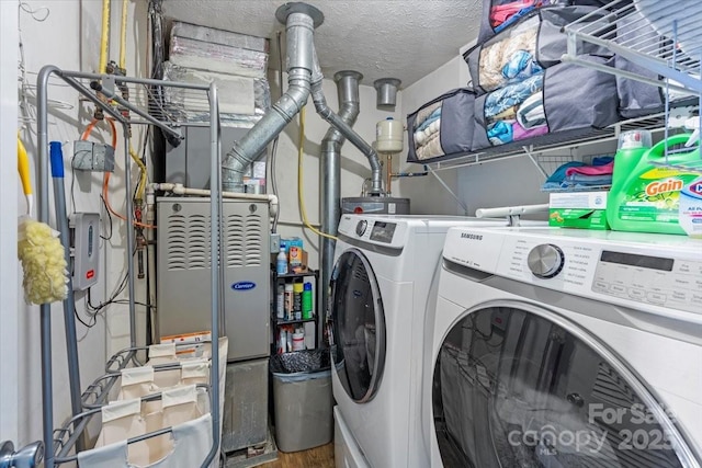 laundry area with washing machine and clothes dryer and a textured ceiling