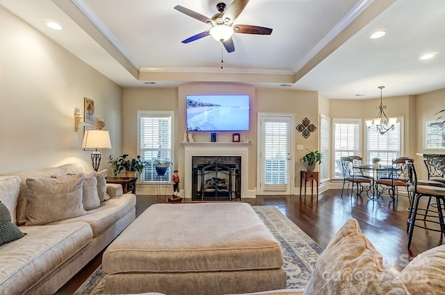 living room featuring crown molding, a wealth of natural light, dark hardwood / wood-style flooring, and a tray ceiling