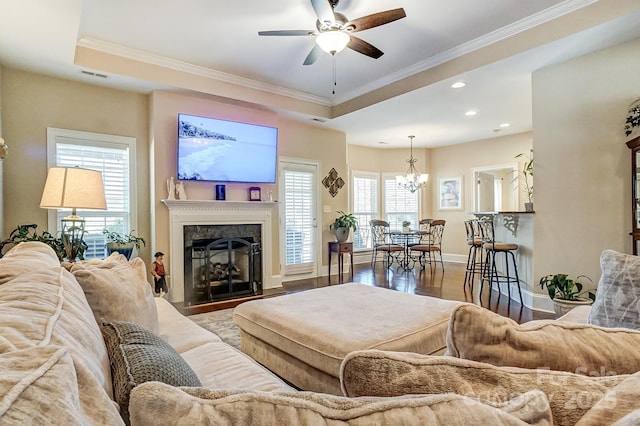 living room featuring crown molding, a tray ceiling, and hardwood / wood-style floors