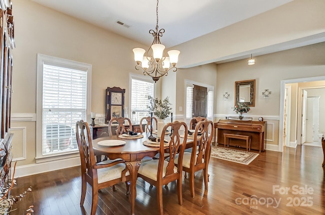 dining space with dark hardwood / wood-style flooring and a notable chandelier