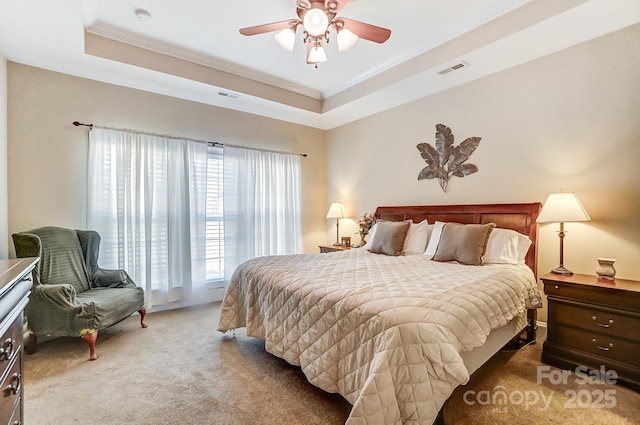 carpeted bedroom featuring crown molding, a tray ceiling, and ceiling fan