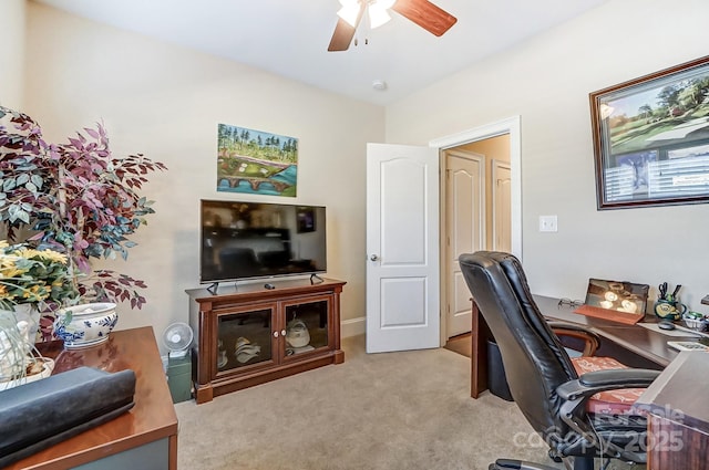 carpeted office space featuring ceiling fan