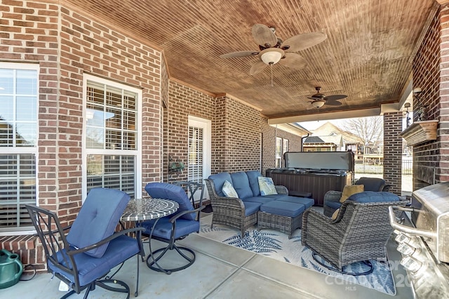 view of patio featuring outdoor lounge area, ceiling fan, and a hot tub