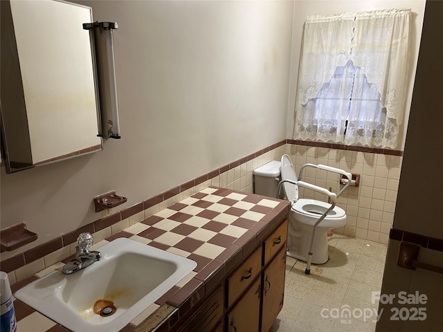 bathroom with vanity, tile walls, and toilet