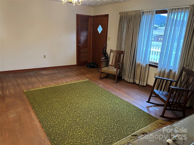 sitting room featuring hardwood / wood-style flooring, a textured ceiling, and a chandelier