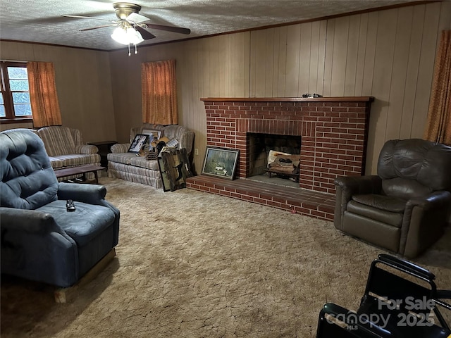 carpeted living room featuring crown molding, a textured ceiling, a fireplace, and wood walls