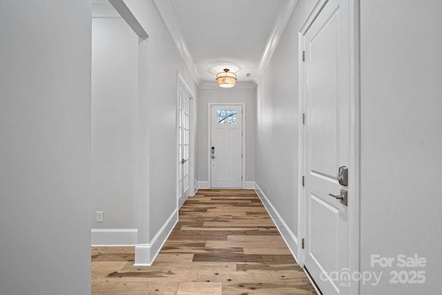 entryway with crown molding and light hardwood / wood-style flooring