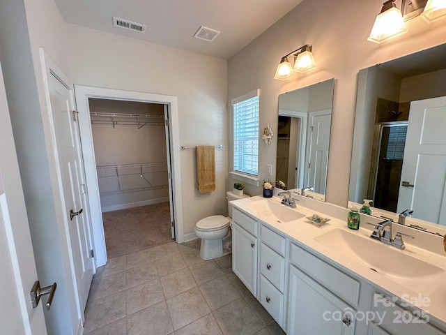 bathroom with tile patterned floors, toilet, a shower with shower door, and vanity