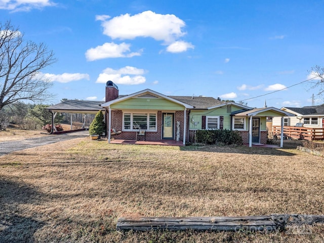 ranch-style home featuring a front lawn and a carport