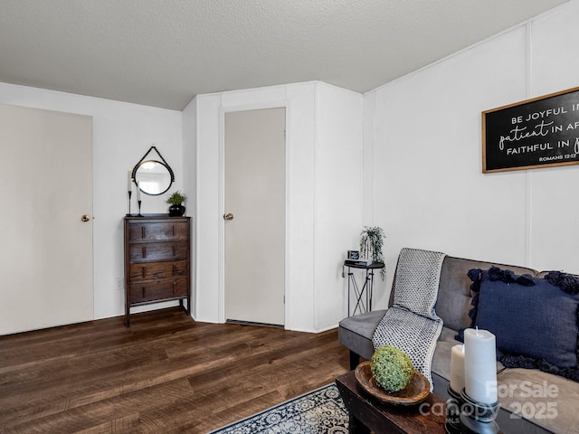 living area featuring dark hardwood / wood-style floors and a textured ceiling