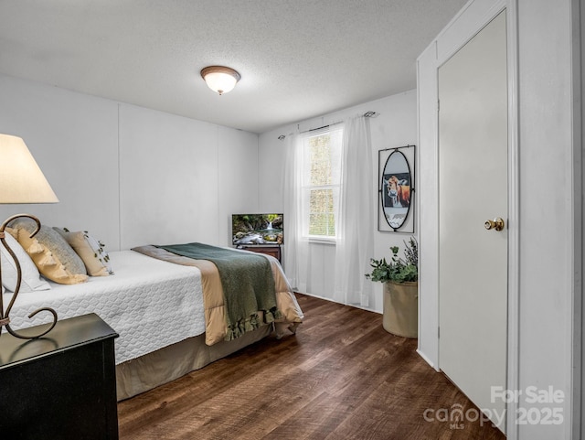 bedroom with dark hardwood / wood-style flooring and a textured ceiling