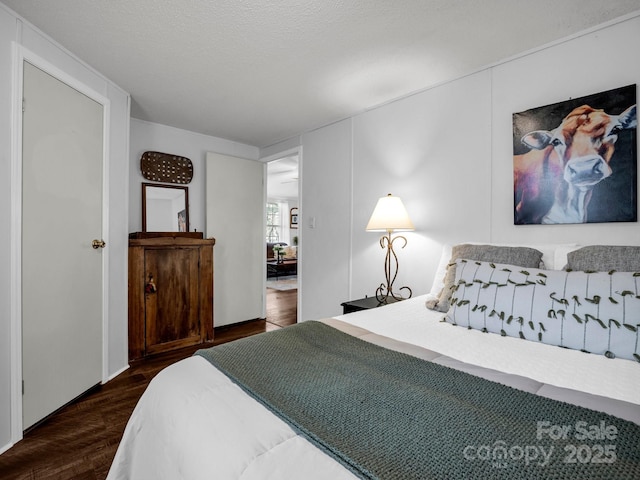 bedroom featuring a textured ceiling and dark hardwood / wood-style flooring