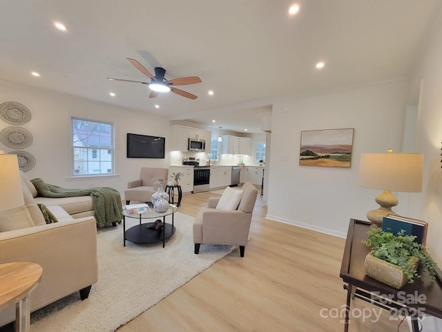 living room featuring ceiling fan and light hardwood / wood-style flooring