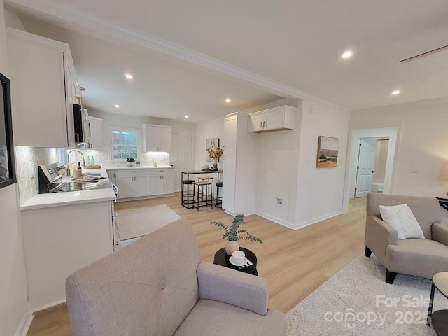 living room featuring light hardwood / wood-style flooring and ornamental molding