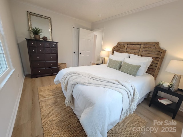 bedroom with ornamental molding and light hardwood / wood-style flooring