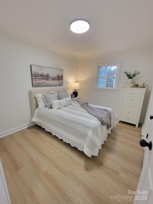 bedroom featuring crown molding and light hardwood / wood-style floors