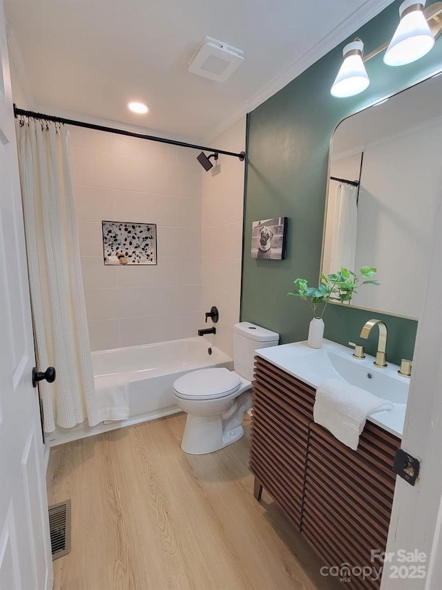 full bathroom featuring toilet, crown molding, wood-type flooring, vanity, and shower / bath combo