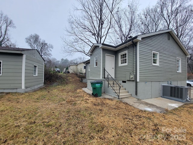 view of home's exterior with a yard and central AC unit