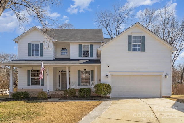 traditional home featuring an attached garage, a front lawn, a porch, and concrete driveway