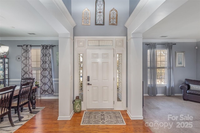 entryway with ornamental molding, baseboards, and wood finished floors