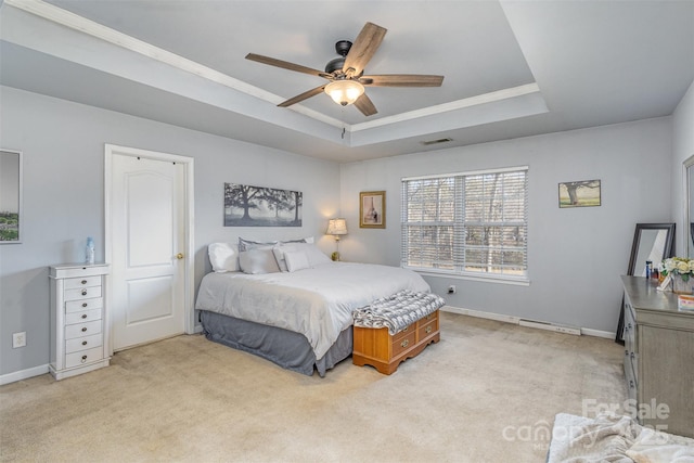 bedroom with a raised ceiling, visible vents, and light colored carpet