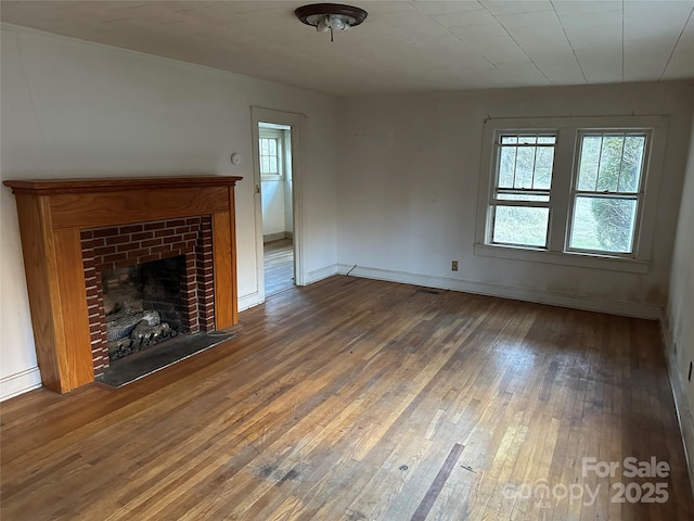 unfurnished living room with dark wood-type flooring and a fireplace