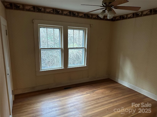 empty room with hardwood / wood-style floors and ceiling fan