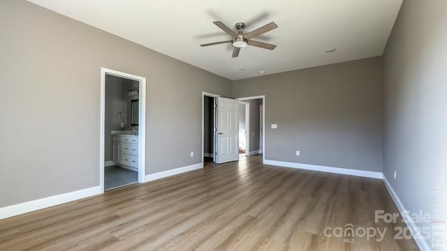 unfurnished bedroom featuring hardwood / wood-style flooring, ensuite bath, and ceiling fan