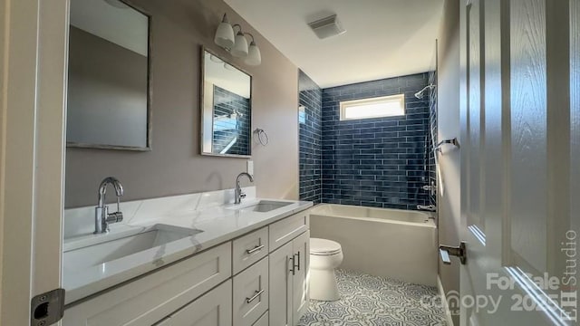 full bathroom featuring vanity, toilet, tiled shower / bath combo, and tile patterned flooring