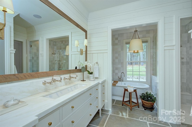 bathroom with a shower stall, a soaking tub, vanity, and tile patterned flooring