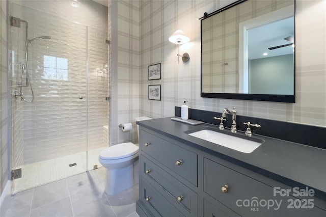 bathroom featuring vanity, a shower stall, wallpapered walls, toilet, and tile patterned floors