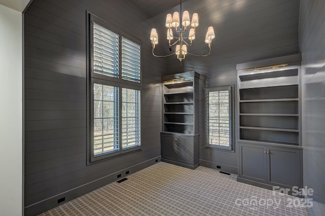 unfurnished room featuring a notable chandelier