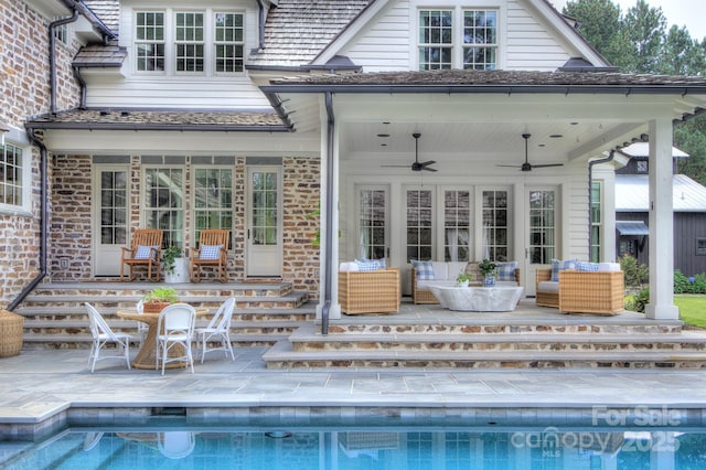 rear view of house featuring a ceiling fan, a patio area, an outdoor pool, an outdoor living space, and brick siding