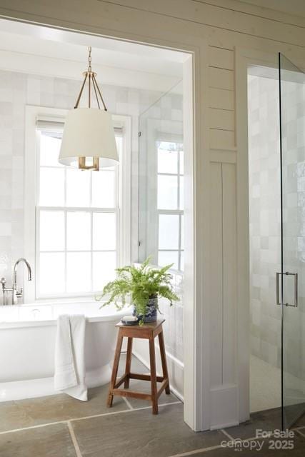 interior space with a freestanding bath, wood finished floors, and a stall shower