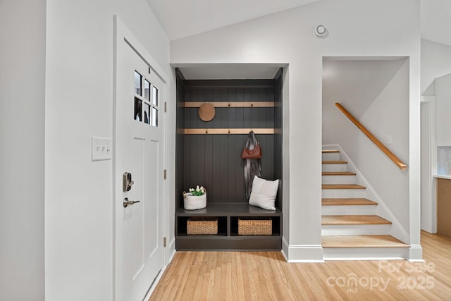 mudroom with vaulted ceiling and hardwood / wood-style floors