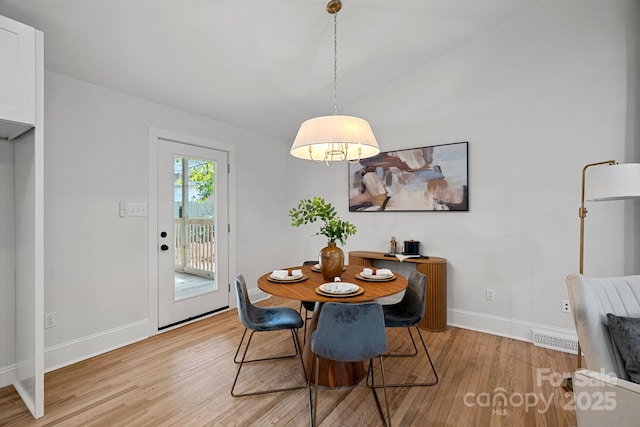 dining space featuring lofted ceiling and light wood-type flooring