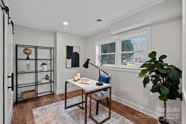 office featuring ornamental molding, a barn door, and dark hardwood / wood-style floors