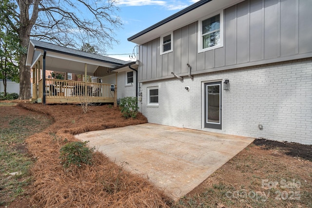 rear view of property featuring a deck and a patio