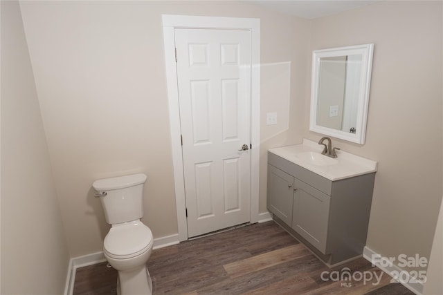 bathroom with vanity, hardwood / wood-style flooring, and toilet