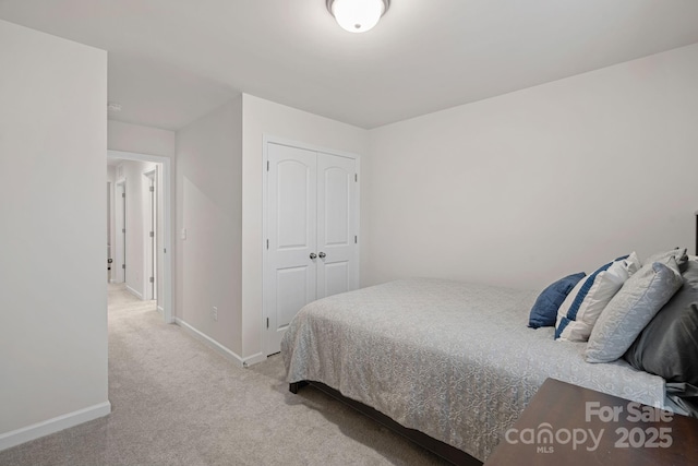 bedroom featuring a closet and light colored carpet